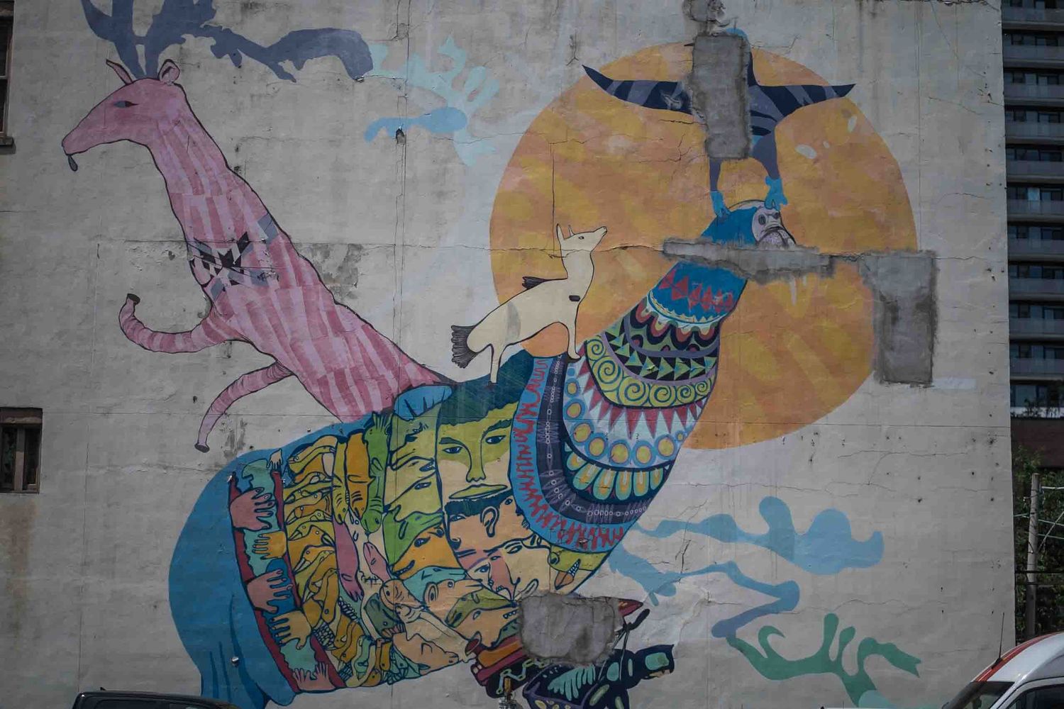 Colorful graffiti mural featuring whimsical characters and abstract designs on a city wall.
