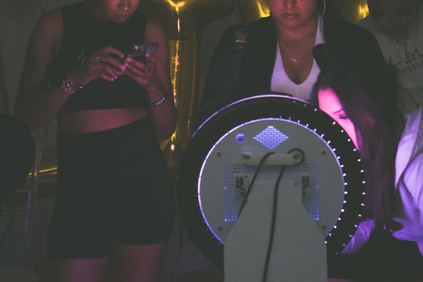 Dark room illuminated by purple lighting and glowing displays.