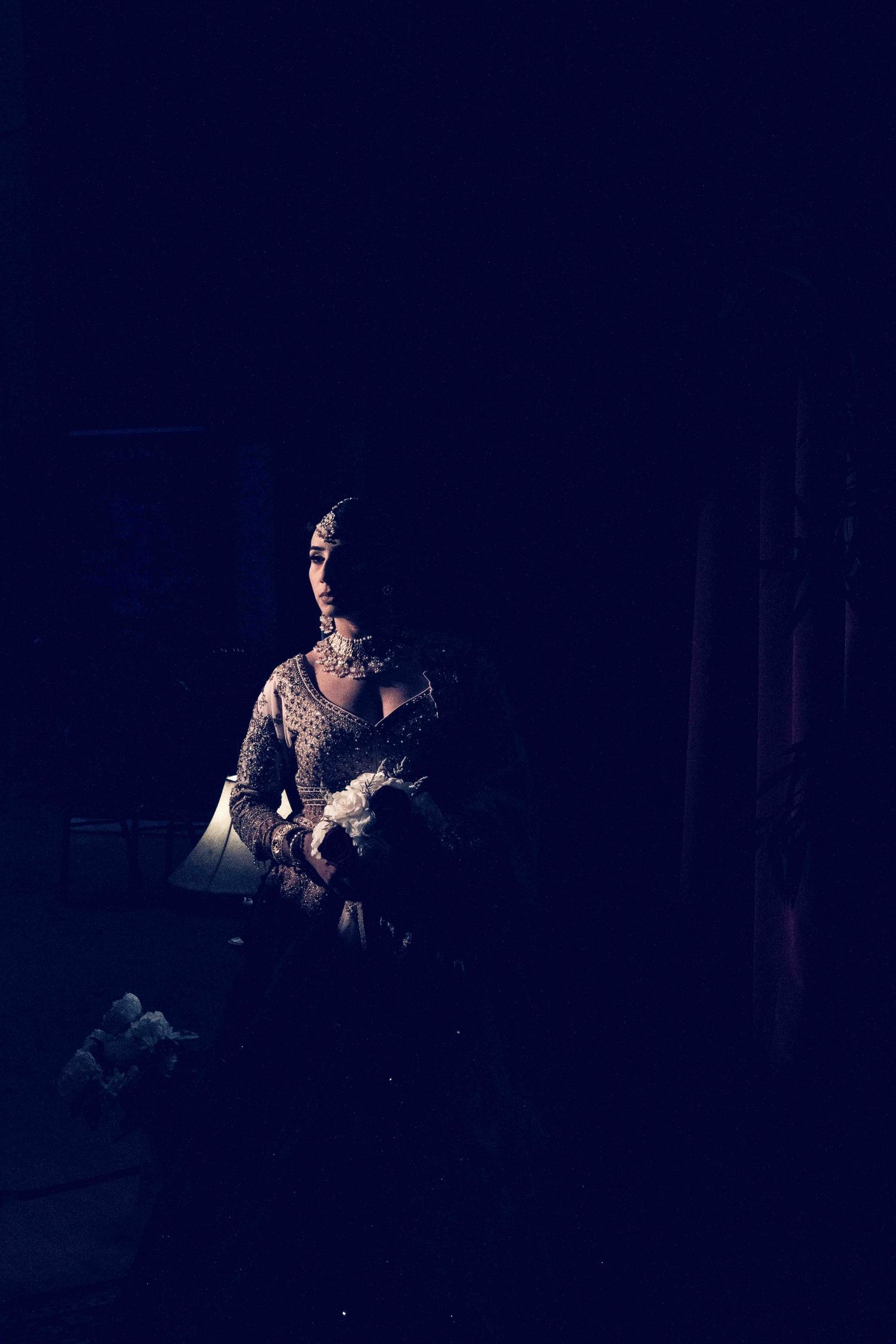 A silhouetted performer on stage in dramatic lighting during a theatrical performance.