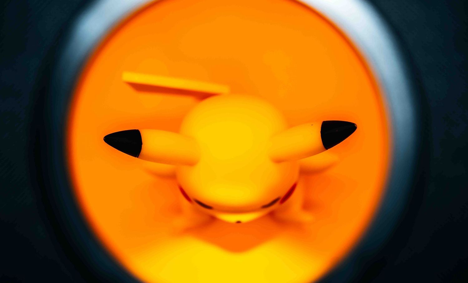 Close-up sequence of a yellow Pikachu toy with changing facial expressions against dark background.