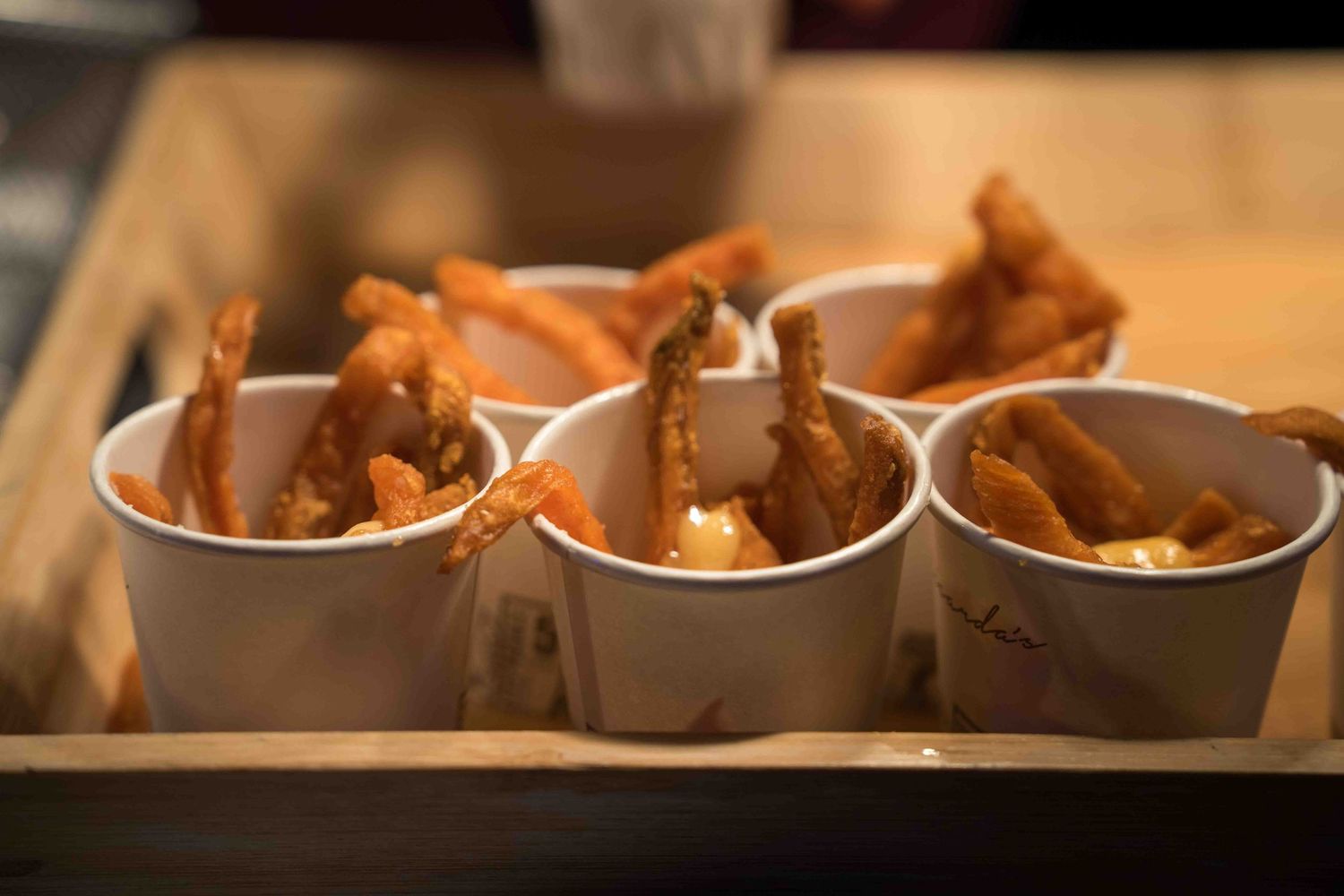 Small portions of appetizers served in individual white serving containers.