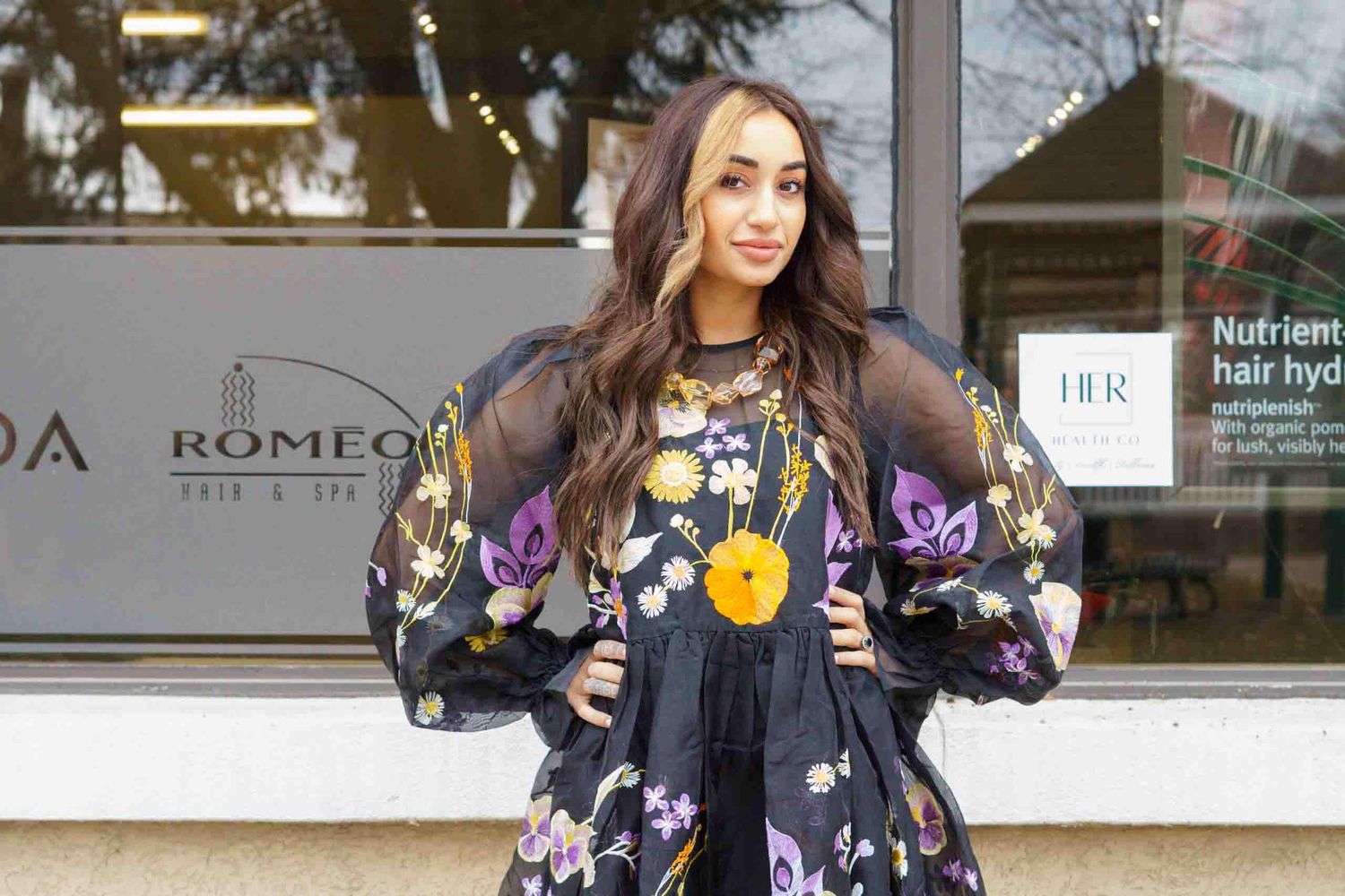 Fashion photography in modern studio with branded signage visible.