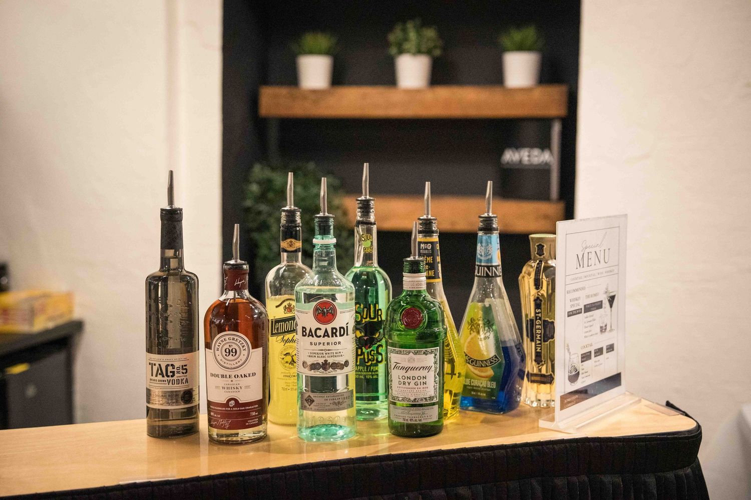 Collection of liquor bottles displayed on wooden shelving.
