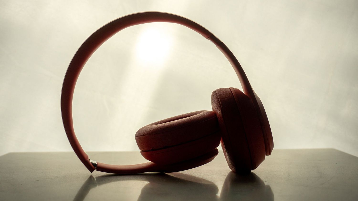 Artistic silhouette progression of headphones against a light gradient background.