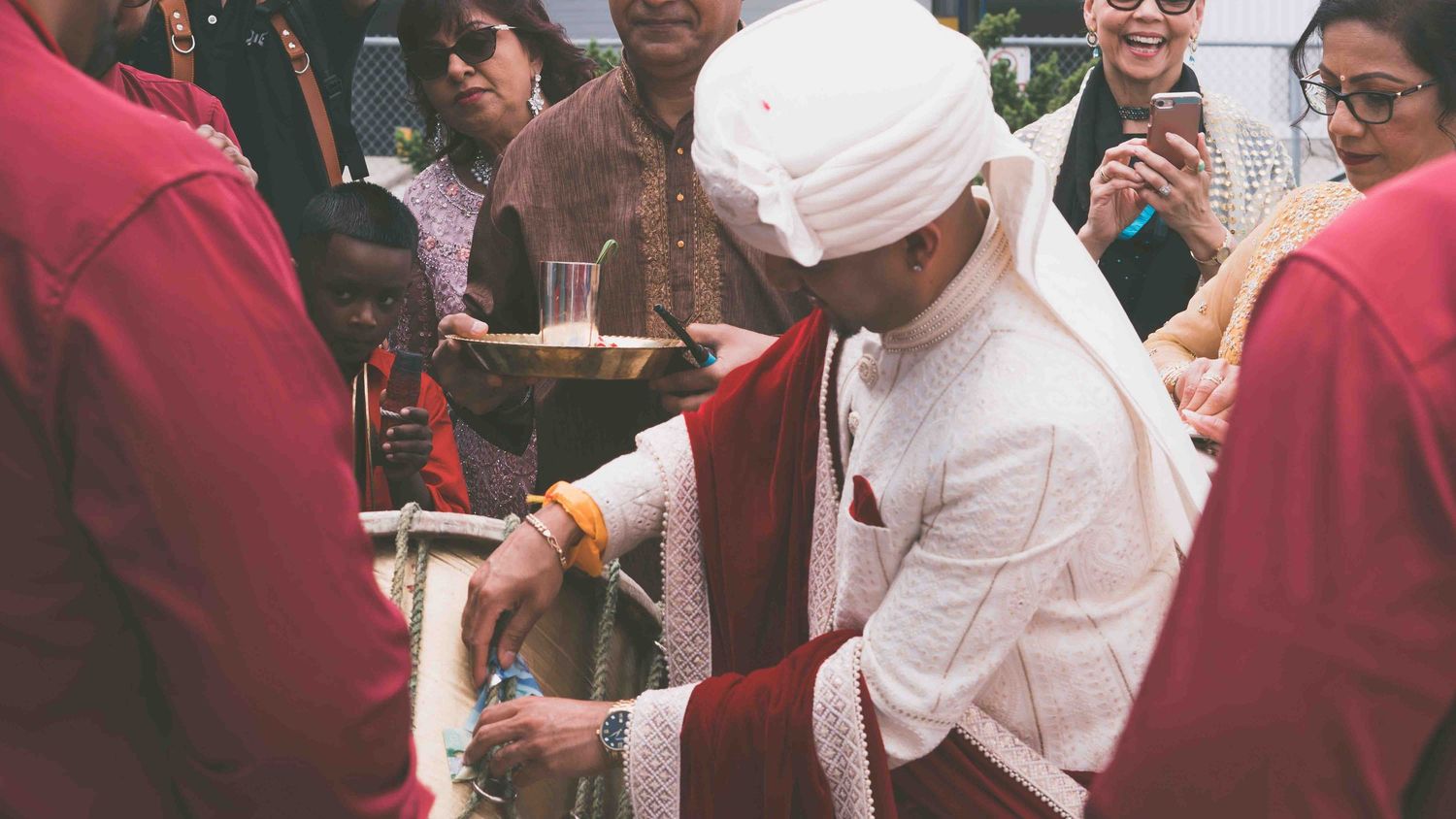 A traditional wedding ceremony showing guests in formal attire gathered around.