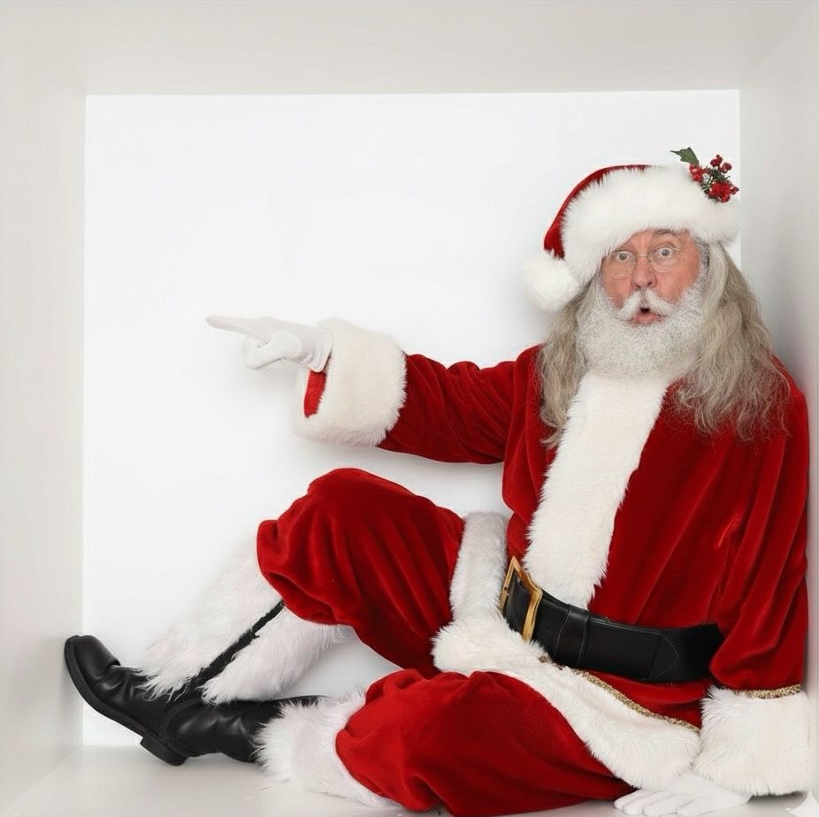 Santa Claus sitting and pointing to the side against a white background.