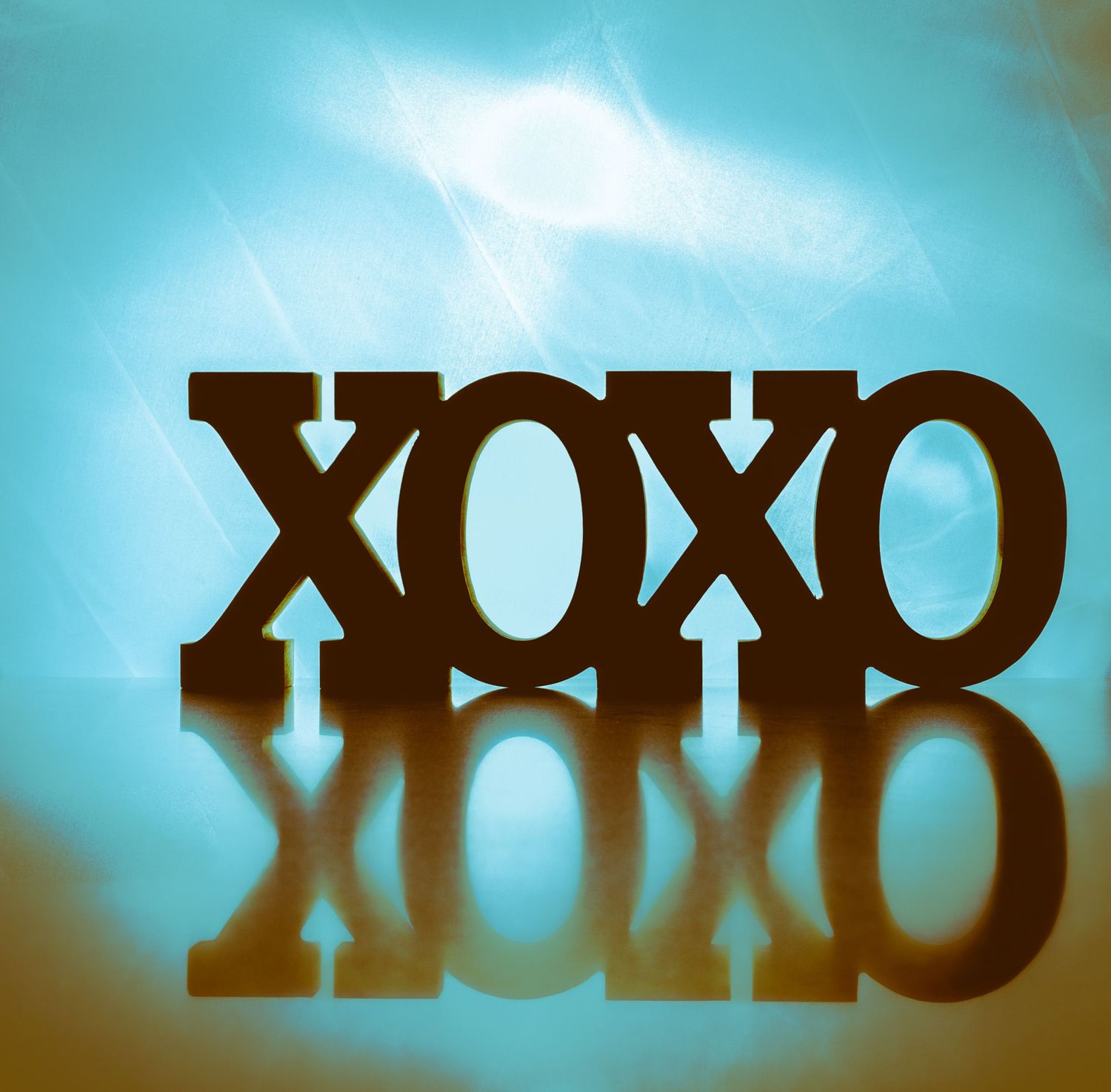 Silhouetted text against a blue background creating an artistic shadow effect.