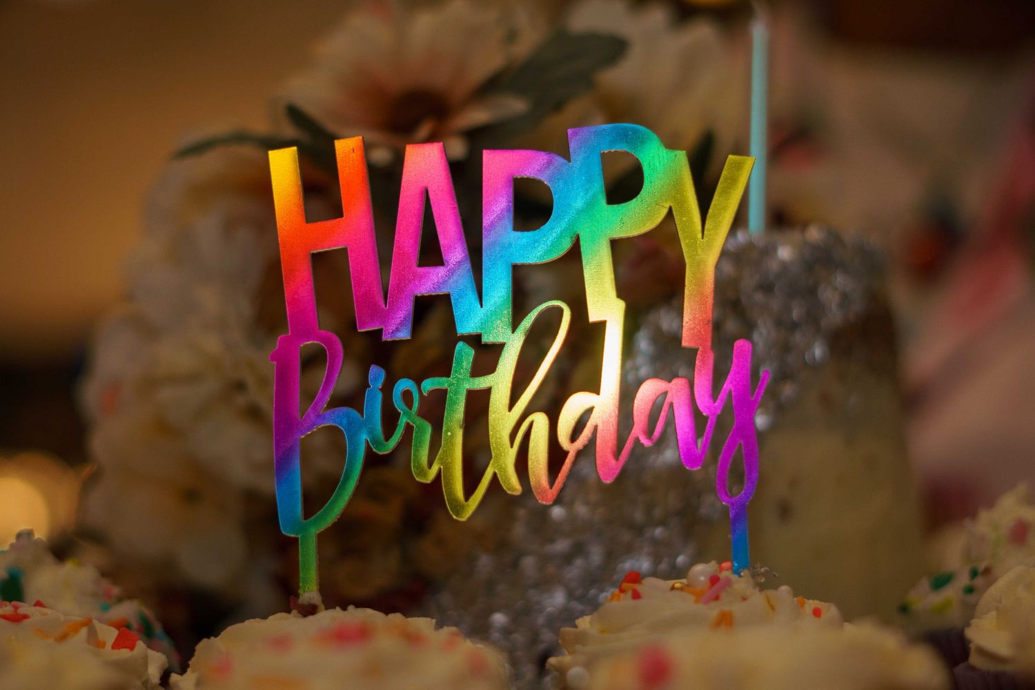 Colorful happy birthday text decoration with rainbow gradient letters.