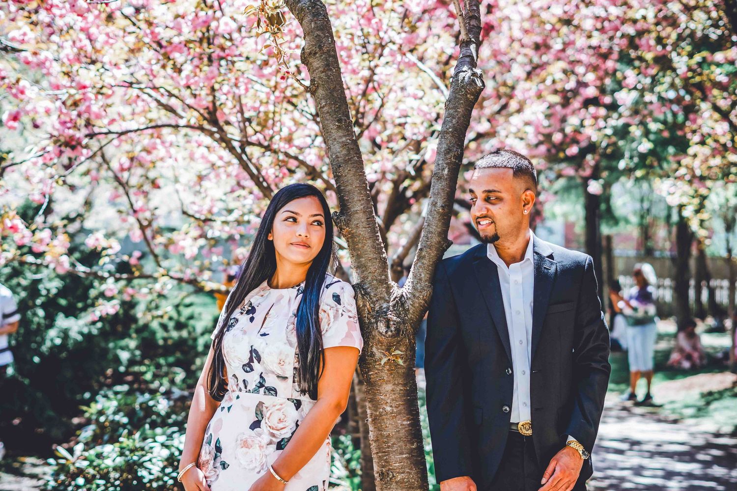Romantic photoshoot under beautiful pink cherry blossom trees on a spring day.