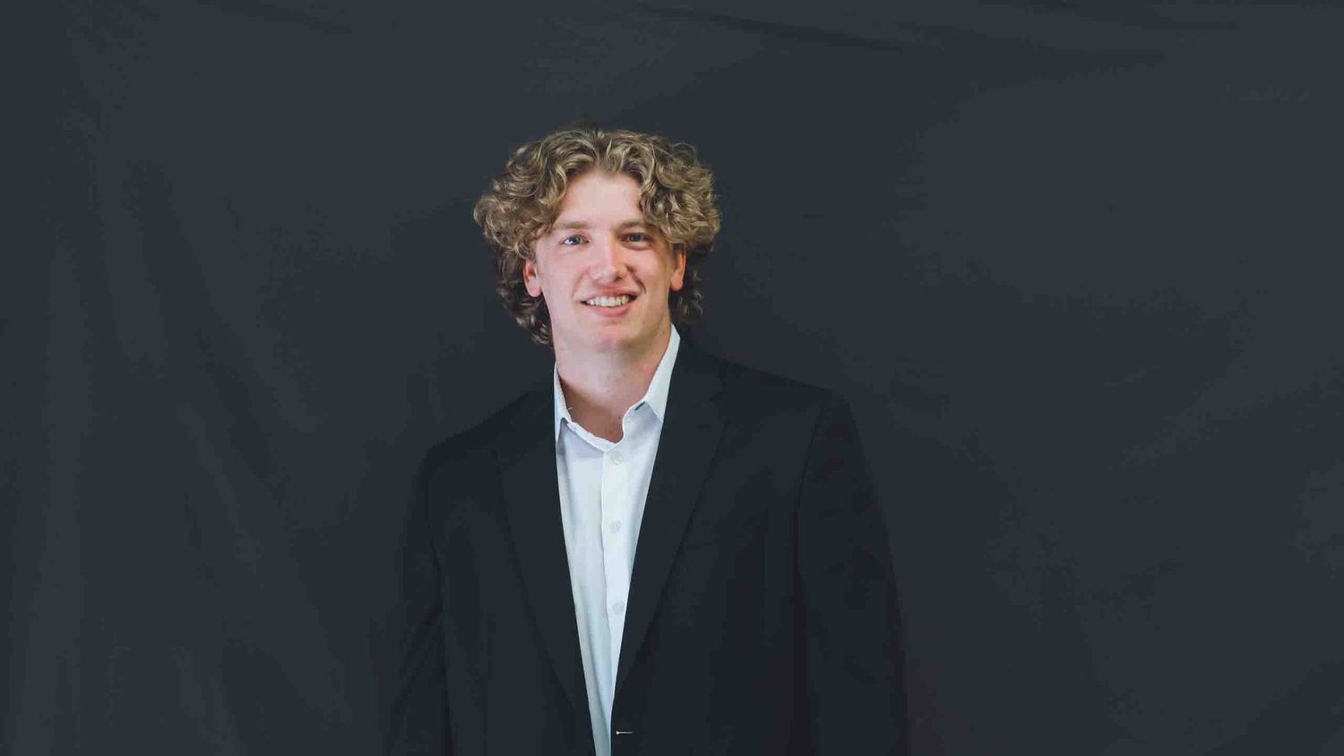 Professional headshot series against dark background showing various expressions.