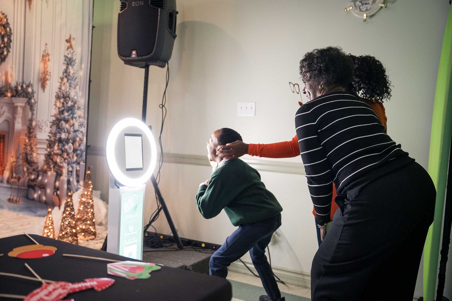 Photographer adjusts lighting equipment and camera settings in a studio during a professional photo session.