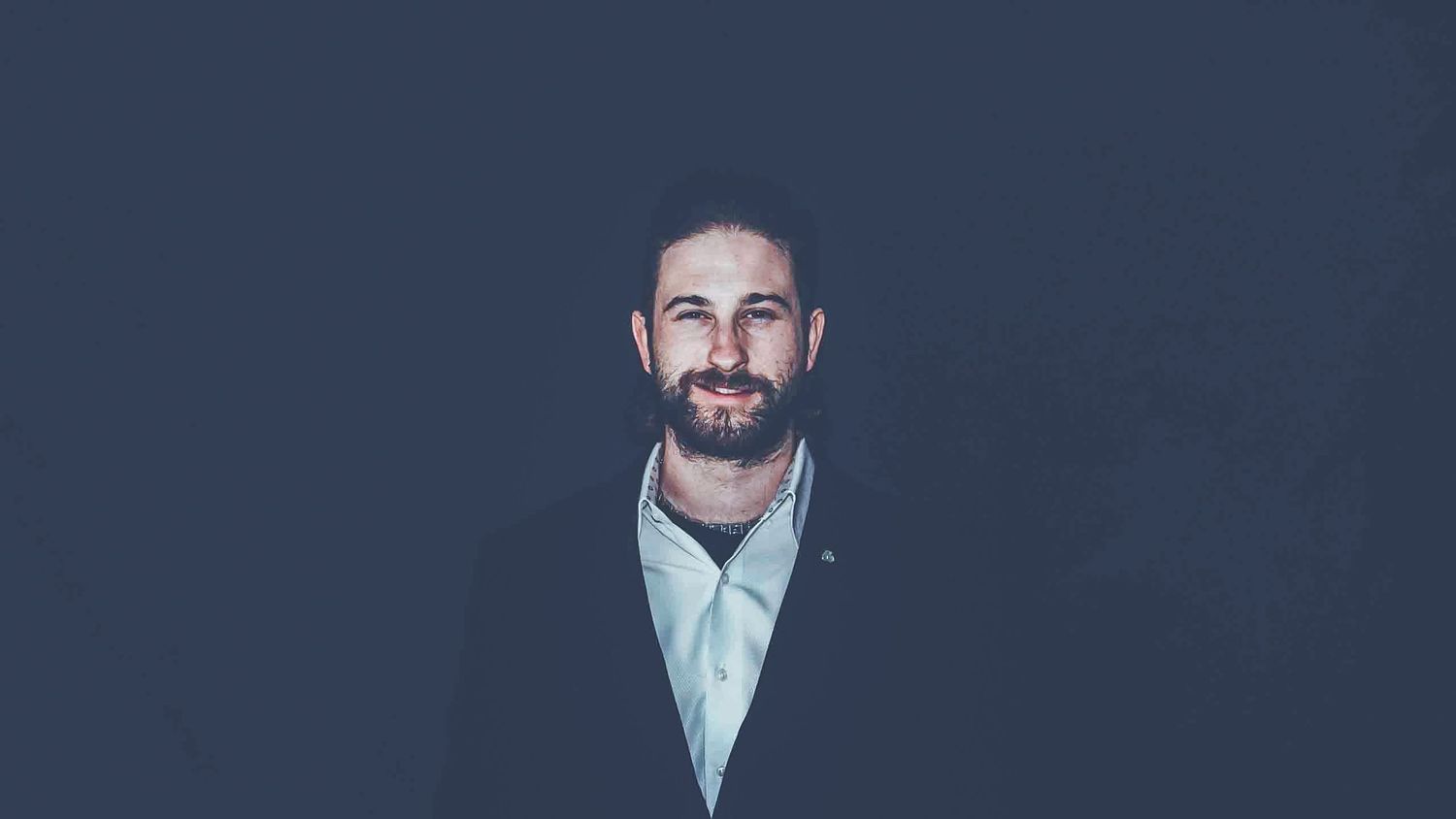Series of business portraits arranged horizontally against dark backdrop.