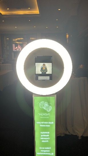 Dark room with illuminated circular light fixture and green digital display screen.