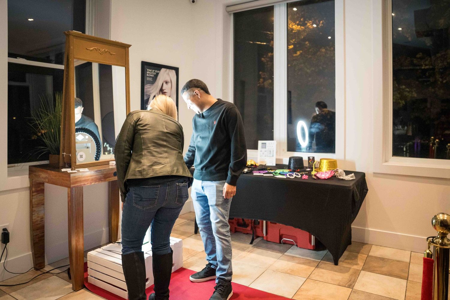 Event attendees interacting with photo booth setup near window display.