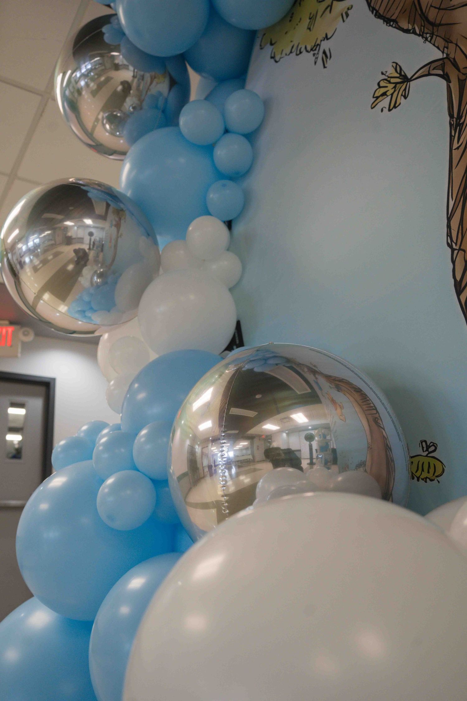 Decorative balloon arch with blue and white balloons featuring clear bubble balloons as accents.