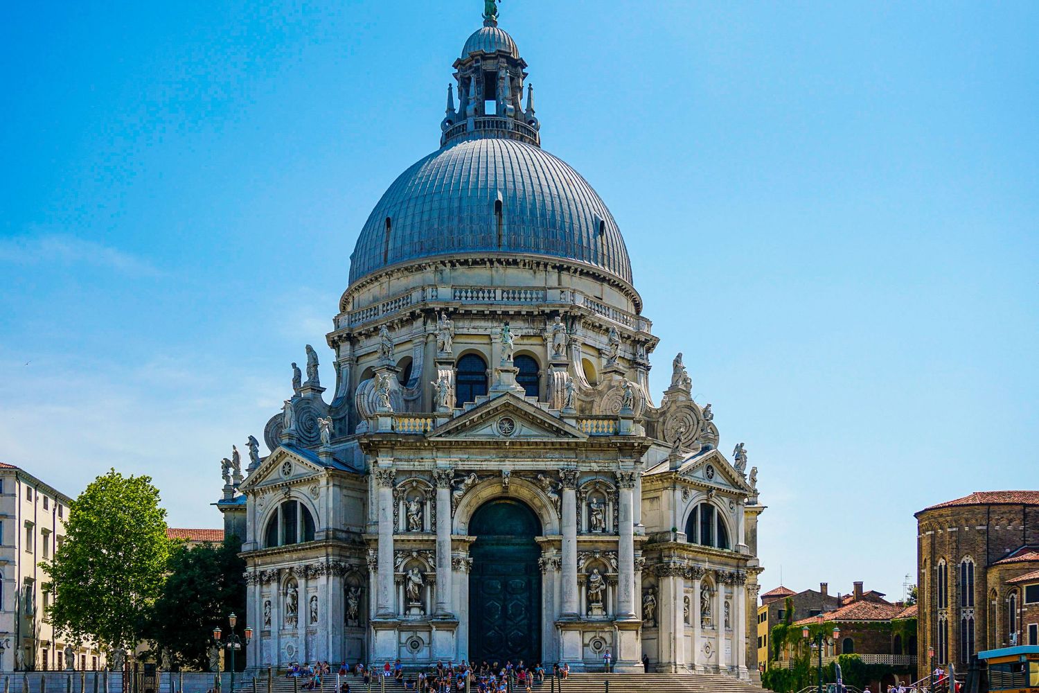 Panoramic view of a grand domed cathedral with classical architecture against blue sky.