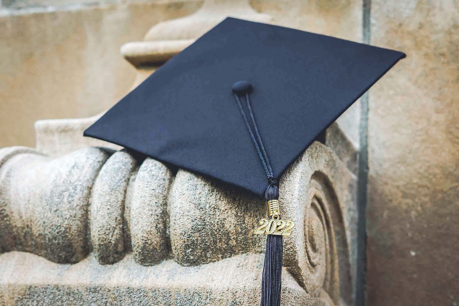 Graduation cap placed on stone architectural detail.