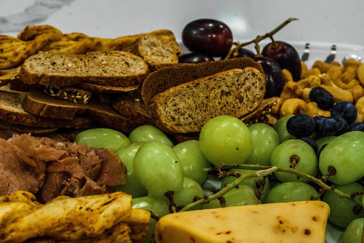 Assorted fresh fruits, pastries and breads arranged on a catering display table.