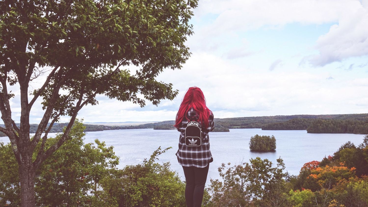 Scenic lakeside views with trees and cloudy skies in autumn.