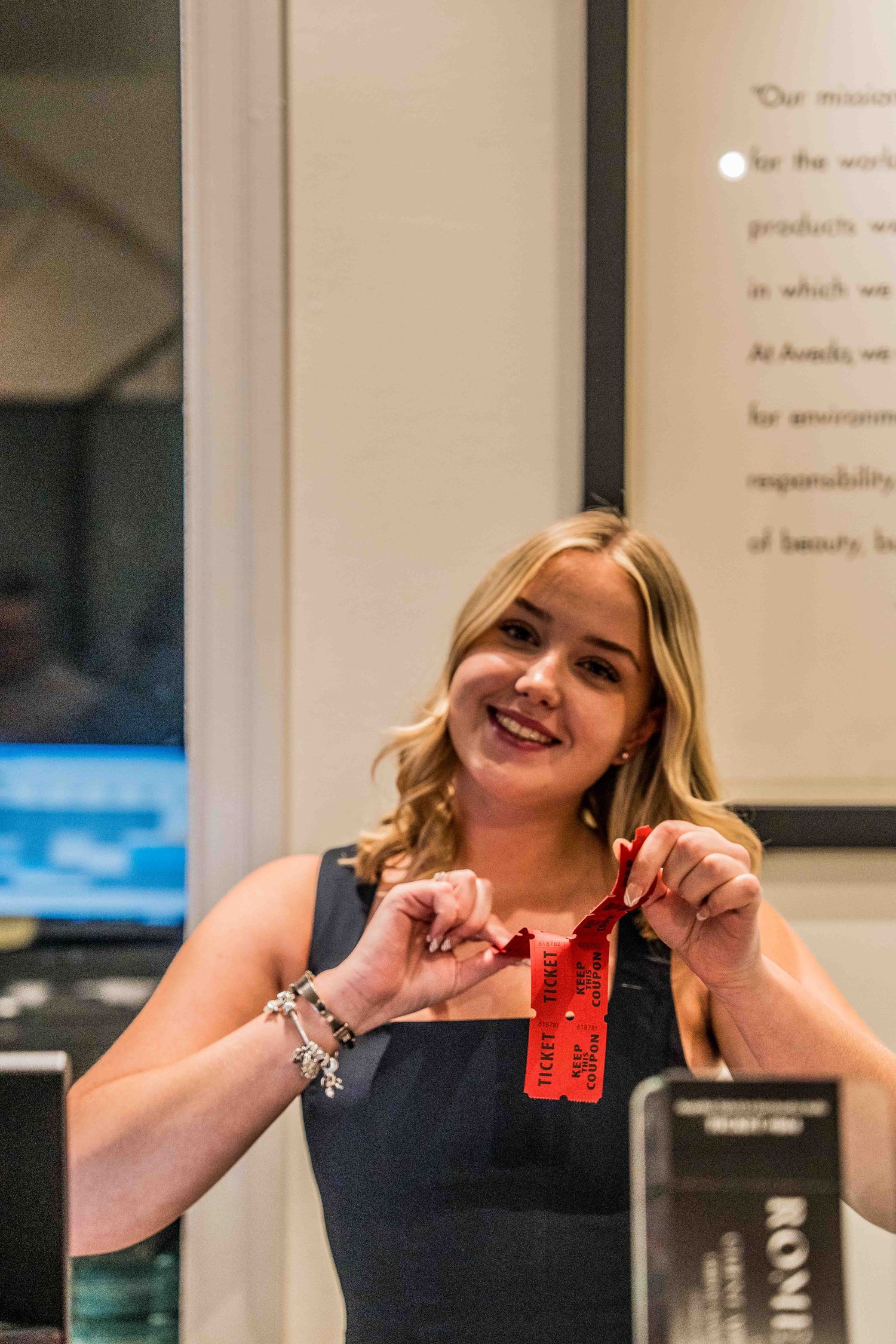 Person showing excitement while holding up red items in a retail setting.