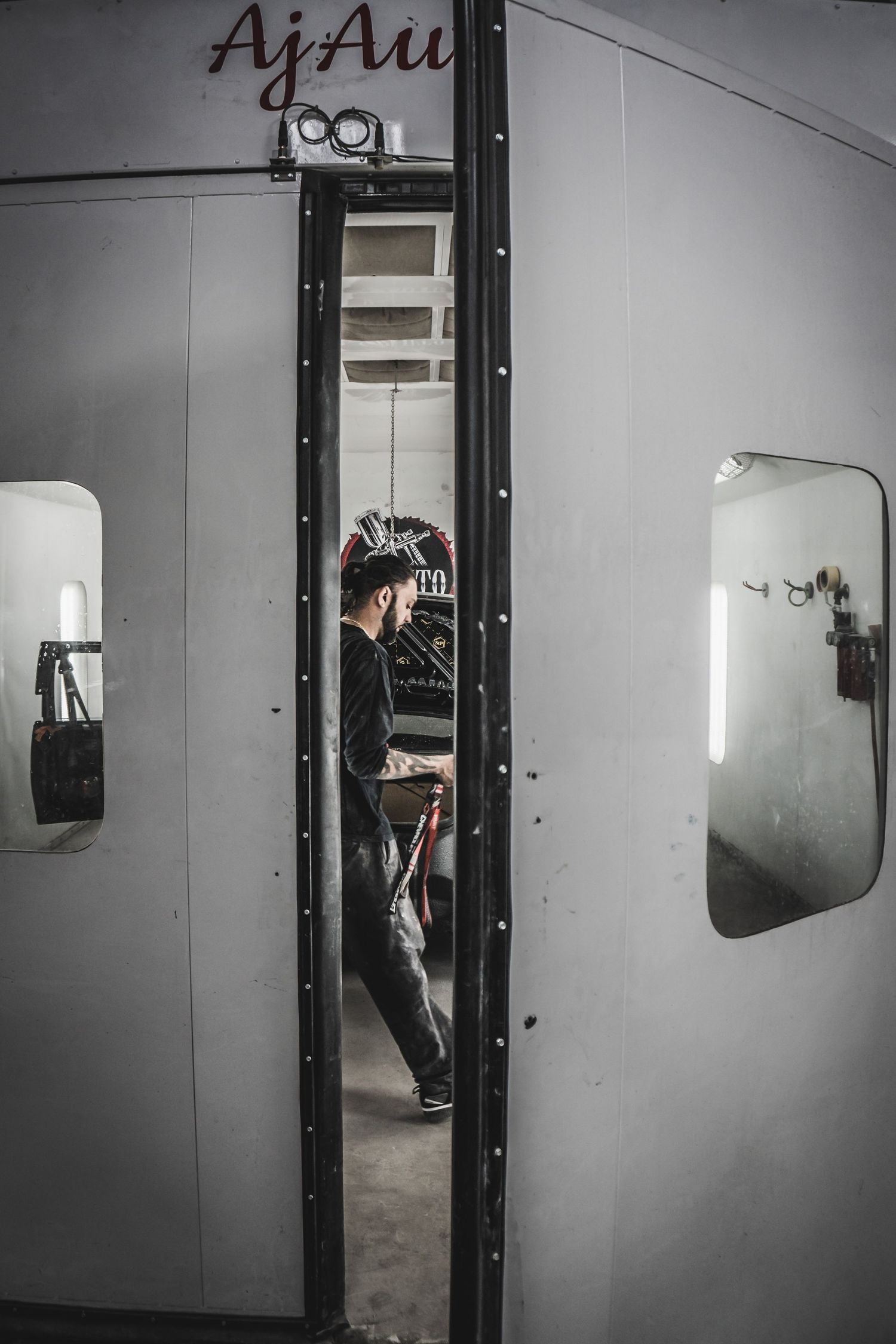 Black and white sequence showing a door opening in a dimly lit industrial space.