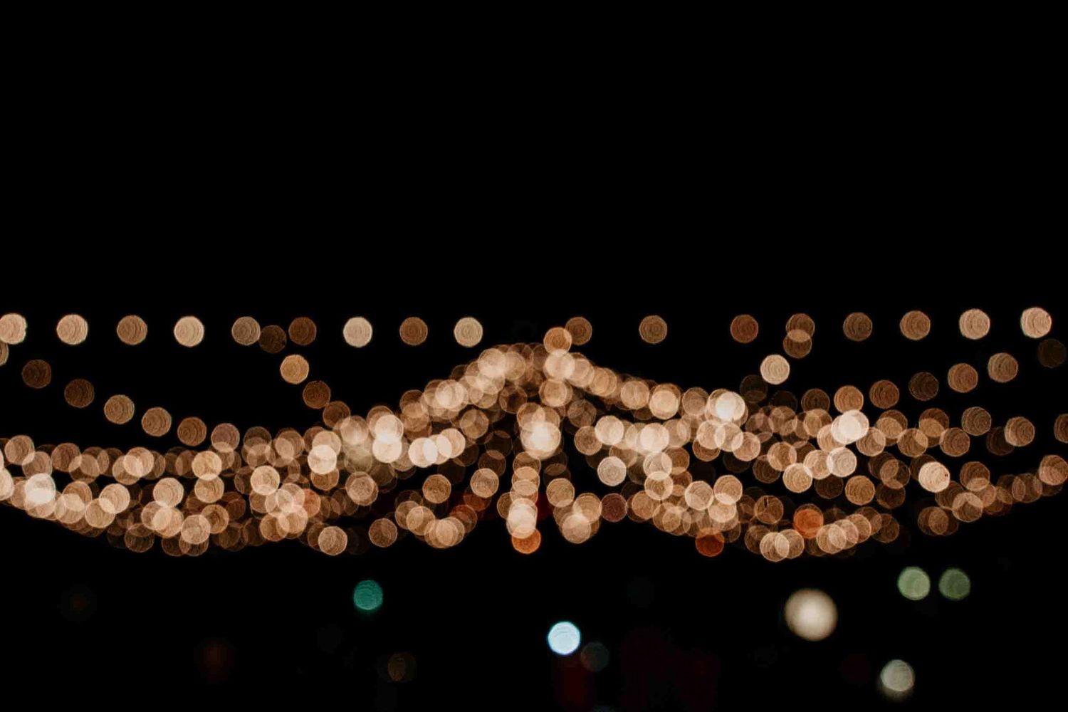 String of warm bokeh lights creating a decorative pattern against dark background.