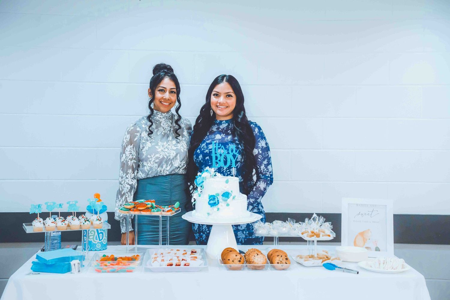 Blue and white themed dessert table setup with cakes and party decorations.