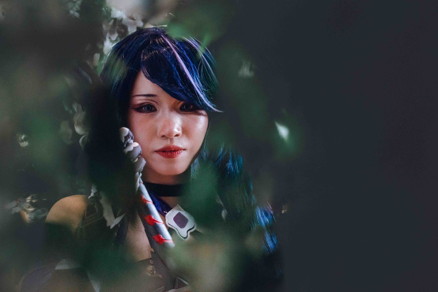 Artistic portrait photography showing dark moody lighting with blue highlights and bokeh effects.