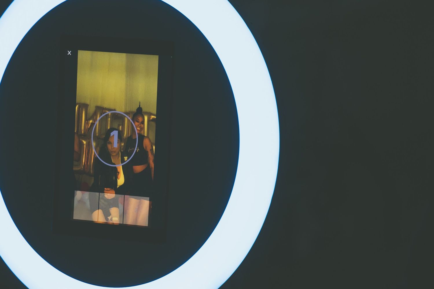 Digital interface screens shown through bright circular ring light display.
