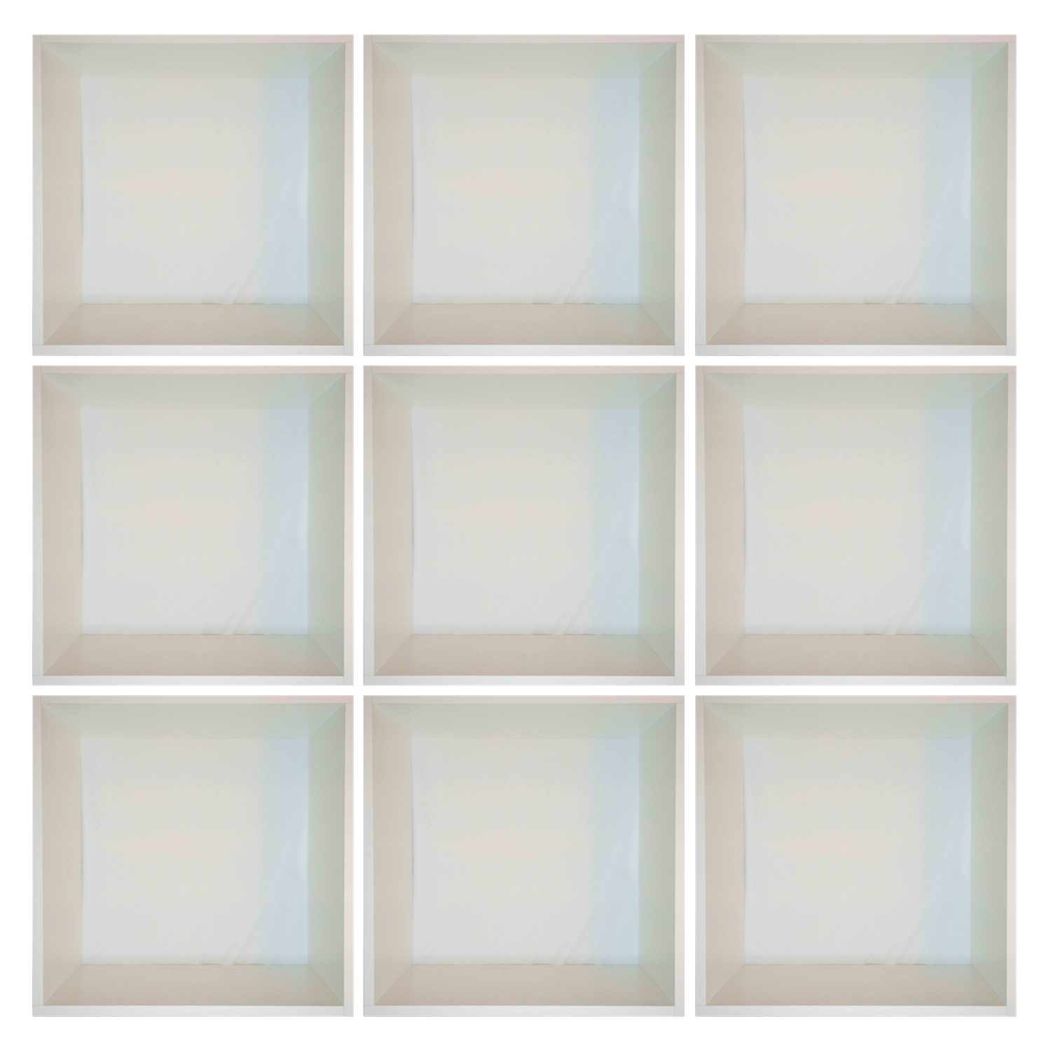 Empty white cube storage unit with nine square compartments and subtle shadows.