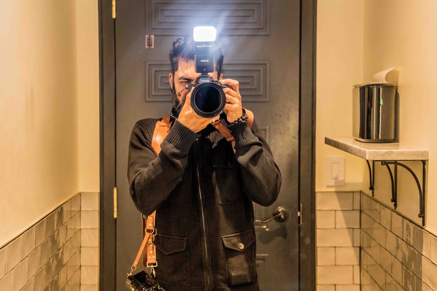 Hallway with geometric patterned doors and a photographer's reflection visible in a mirror.