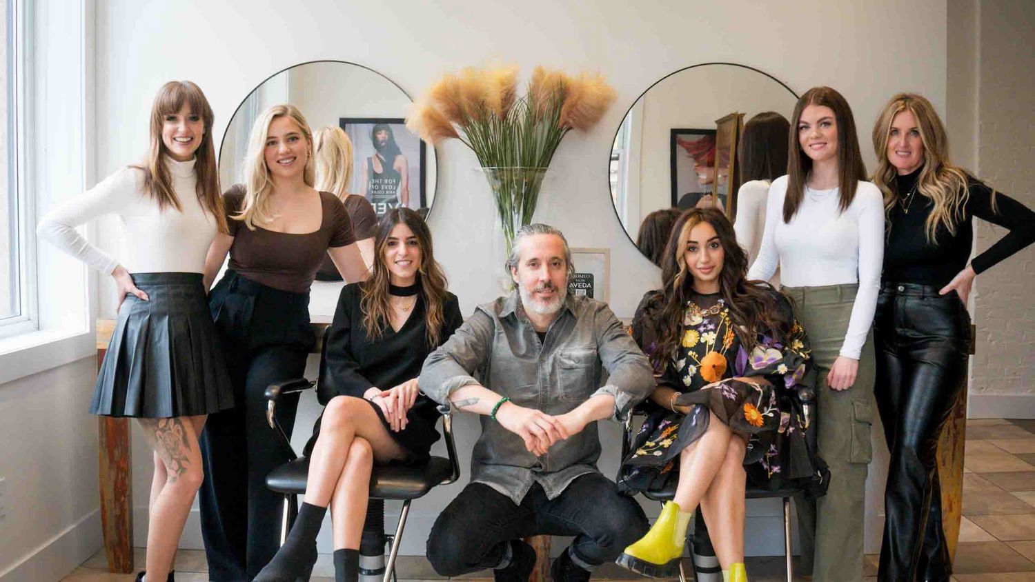 Group photo session in a bright modern studio space with circular mirrors on white walls.
