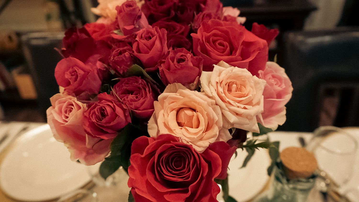 Close-up view of pink and red roses in a romantic floral arrangement.