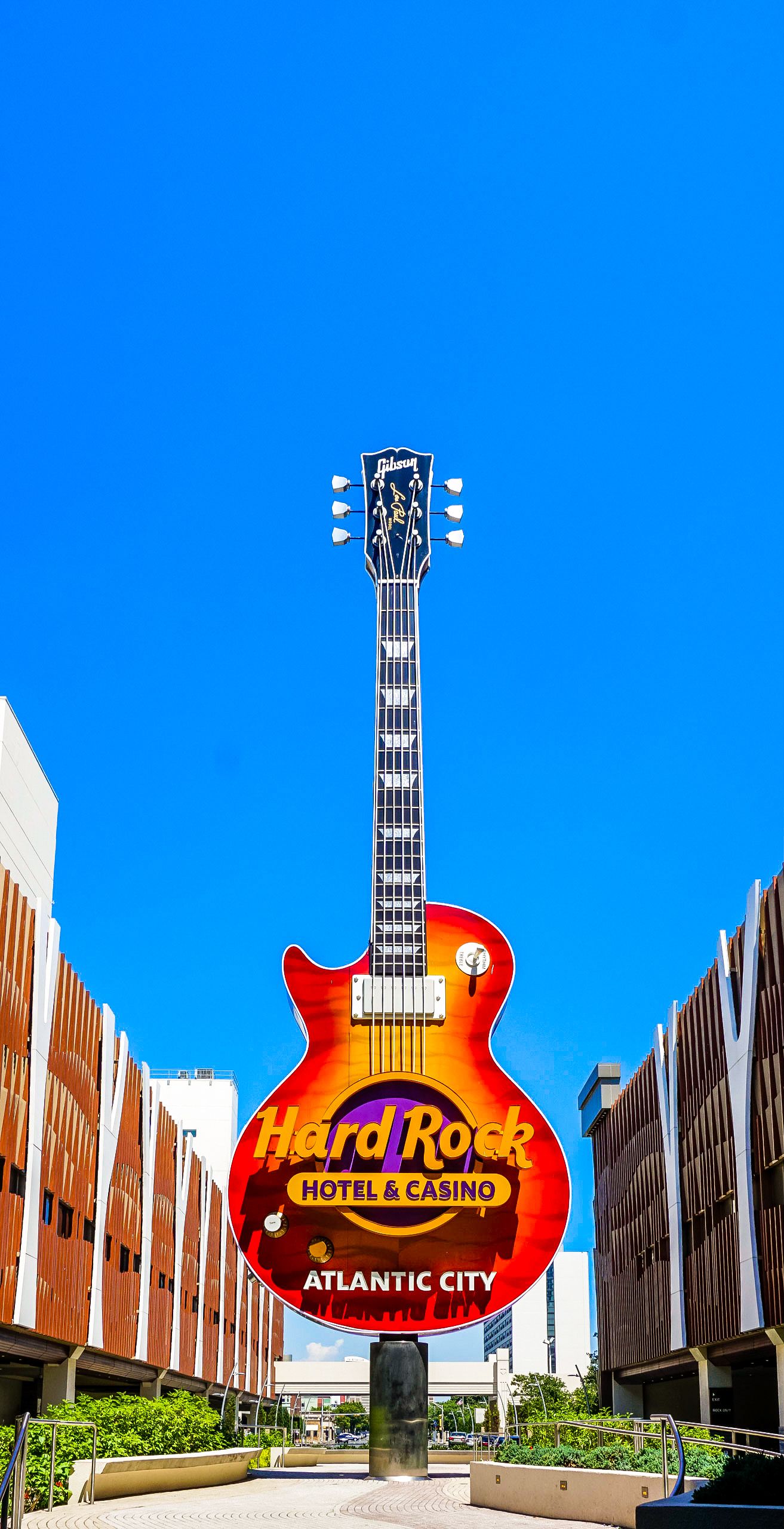 Hard Rock Hotel and Casino sign against bright blue sky in Atlantic City with modern architecture.