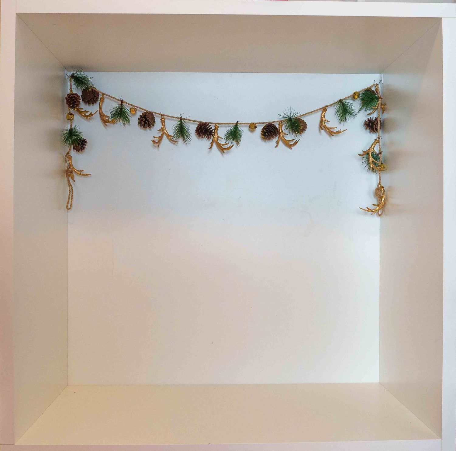 White shelf decorated with delicate green vine garland.