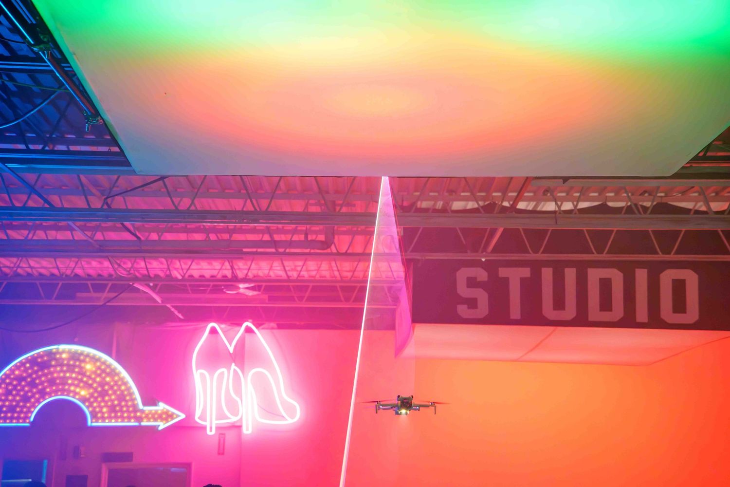 Colorful gradient lighting display with green, orange and pink hues across a studio space.