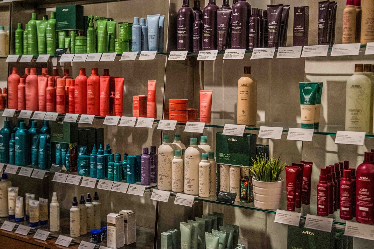 Colorful hair care products neatly arranged on shelves with price tags in a beauty supply store.