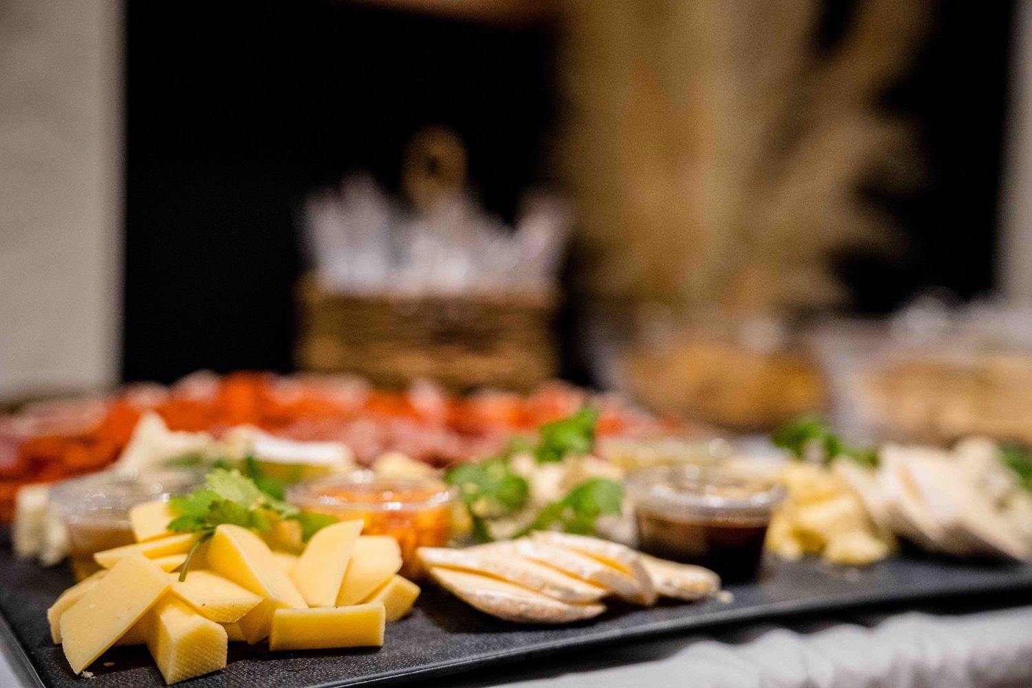 Close-up of artfully arranged meat and cheese platters with garnishes.