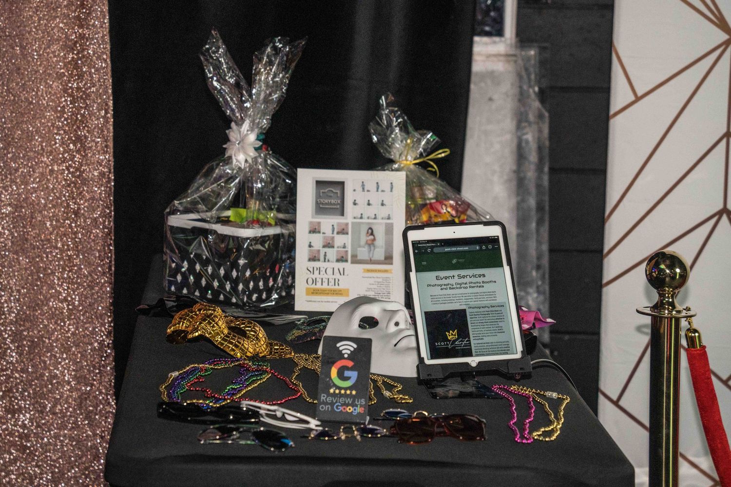Display table with decorative items and promotional materials against patterned wall backdrop.