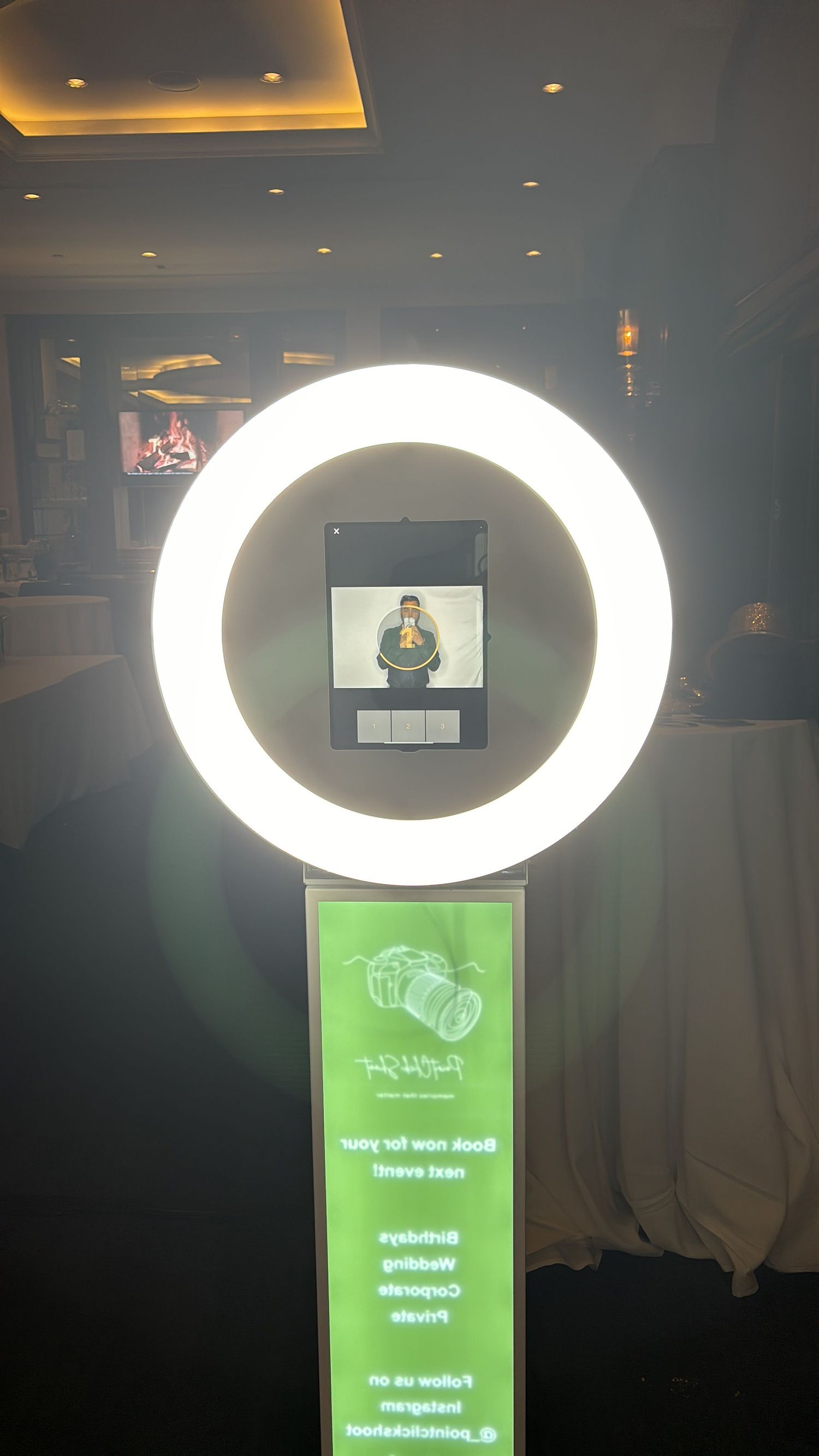 Professional ring light installation with mounted screen display in dimly lit environment.