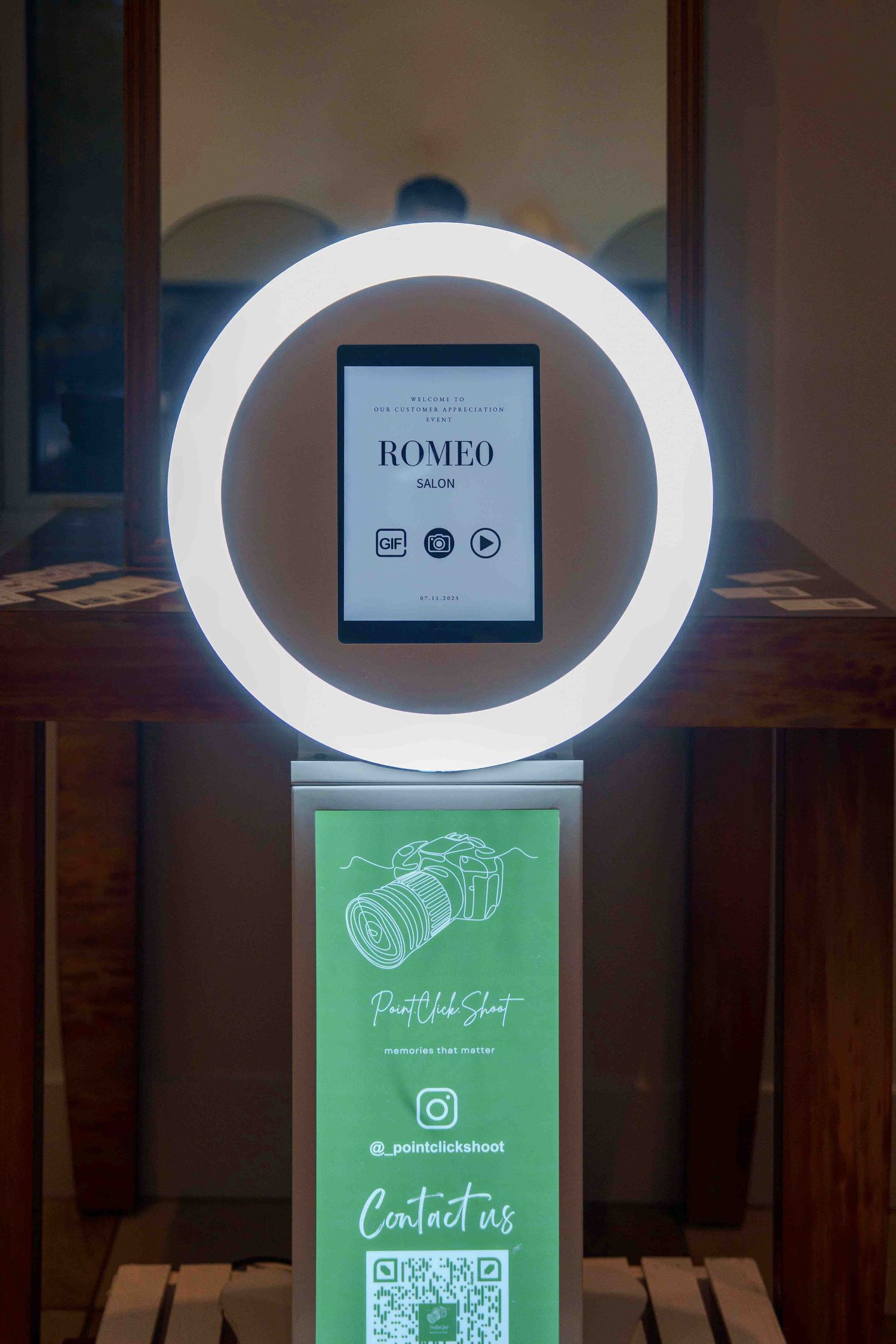 Modern ring light selfie station with social media display and QR code setup.