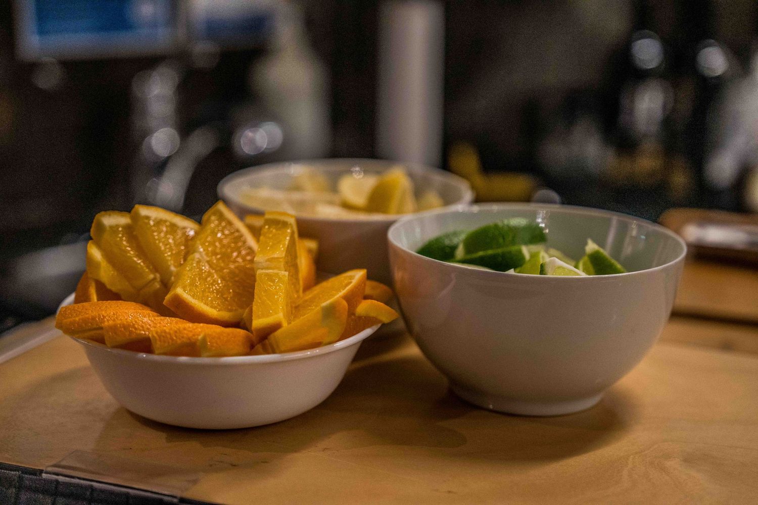 Appetizer spread with tortilla chips and dips on wooden table.