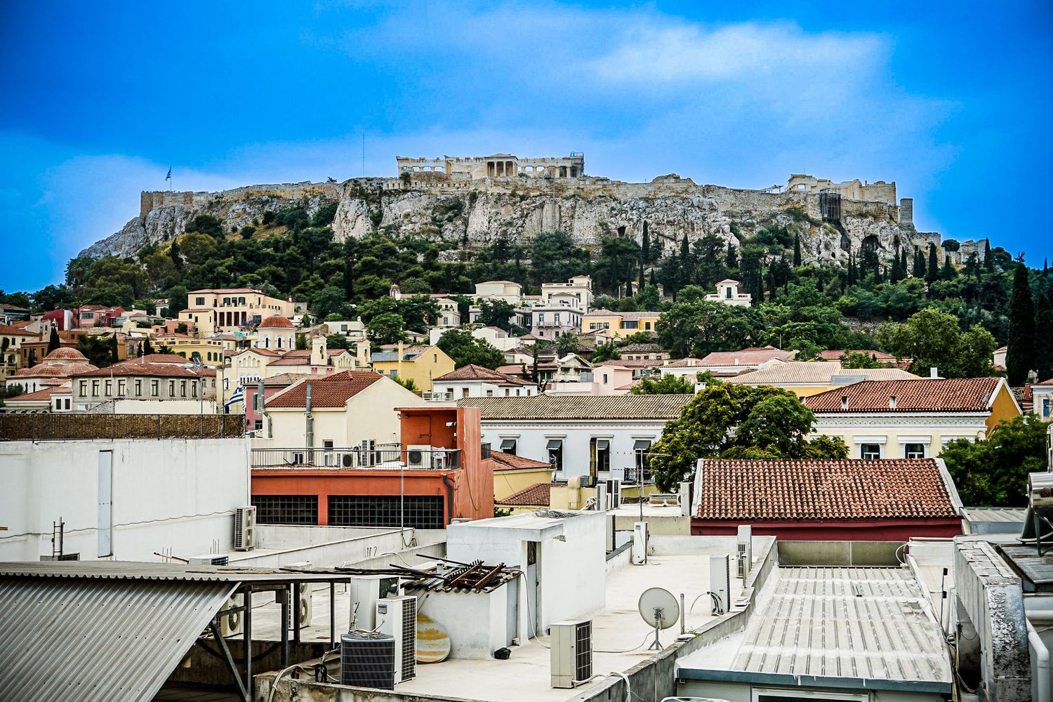 View of the Acropolis perched atop Athens with modern buildings in foreground.
