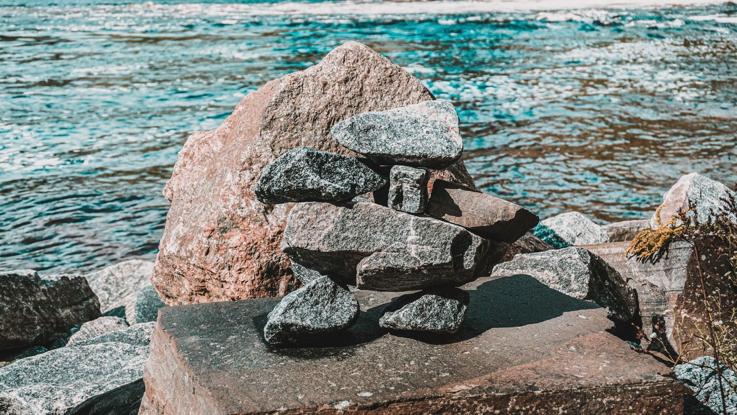 Rocky shoreline with turquoise waters and large granite boulders along the coast.