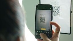 Close-up of fingers tapping on a wall-mounted digital touchscreen display.
