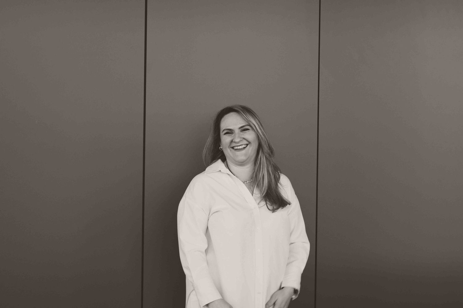 Professional headshots against neutral background showing genuine expressions.