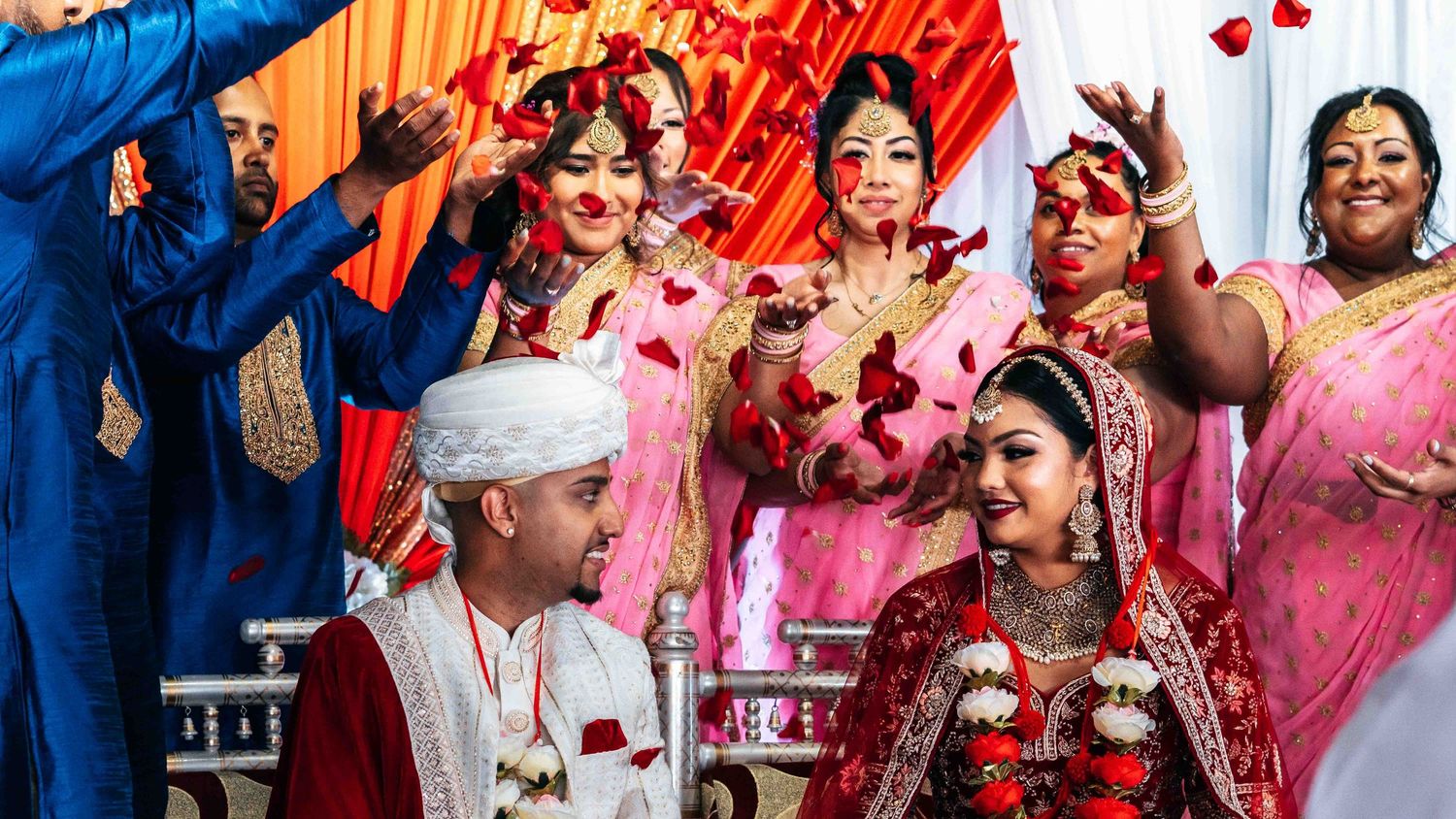A joyous Indian wedding celebration with attendees in colorful traditional attire.