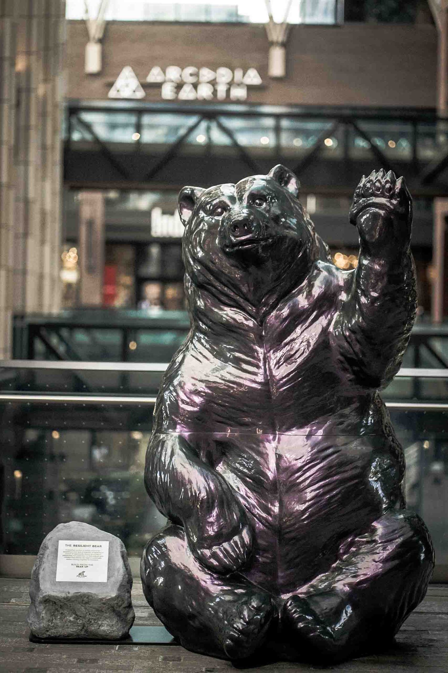 Large decorative black bear statue waves outside Arcadia Earth entrance.