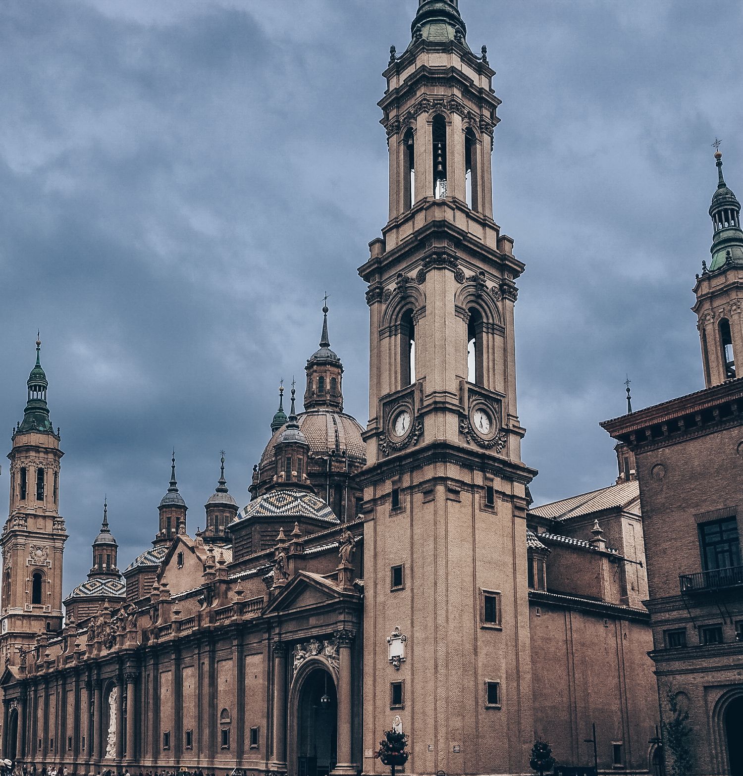 Gothic church spires and towers reaching into dramatic cloudy sky showing ornate architectural details.