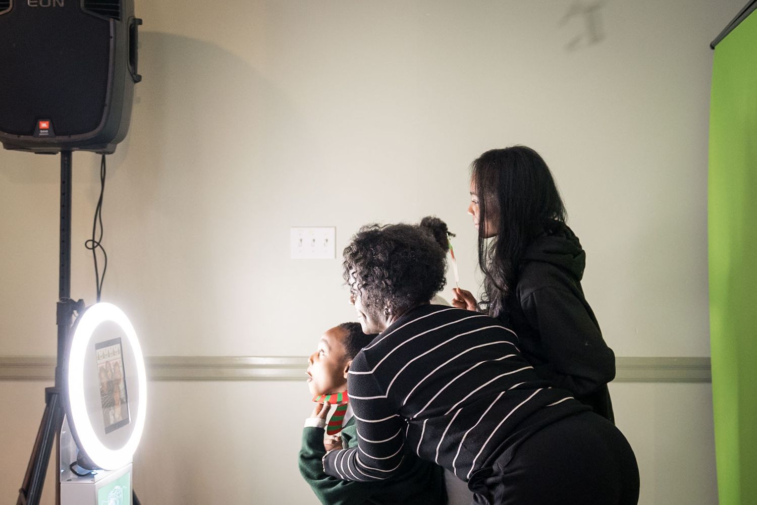 Studio photography session with lighting equipment and green backdrop.